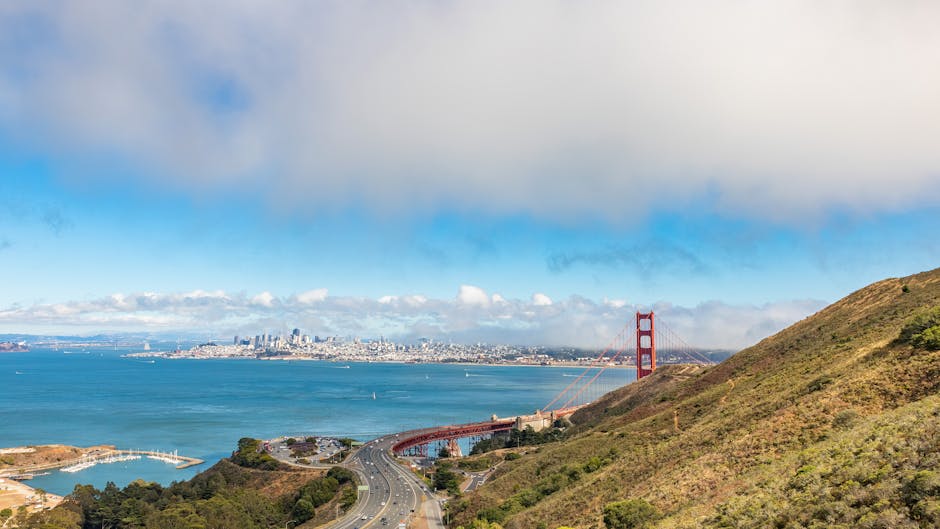 Breathtaking view of the Golden Gate Bridge and San Francisco skyline under a blue sky.