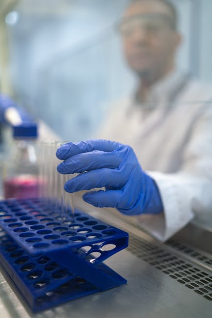 Close-up of a scientist handling test tubes in a laboratory environment.