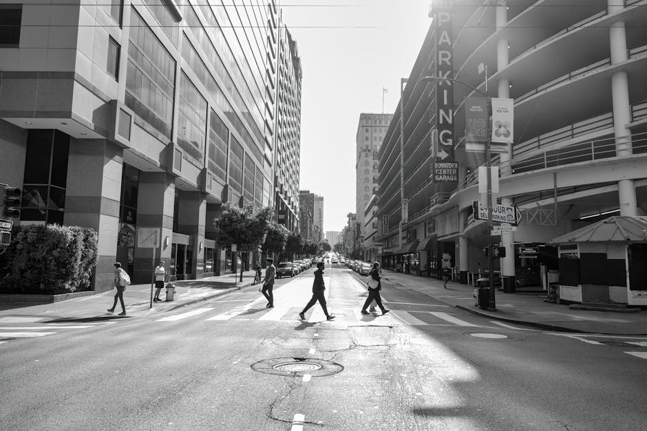 Pedestrians crossing a downtown street in San Francisco's urban landscape.